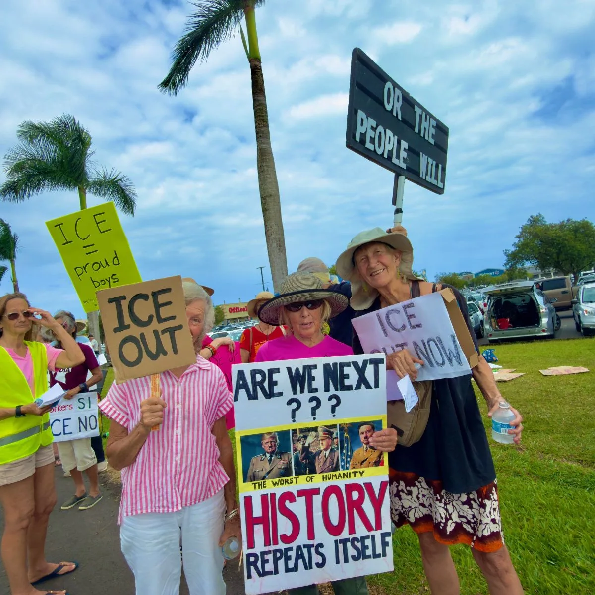 Group of people posing with their postcards at the weekly postcarding party in Kailua, hosted by the Blue Wave and Indivisible Windward Oahu.